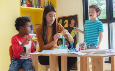 Image of a pediatric therapist working with children in a school setting.